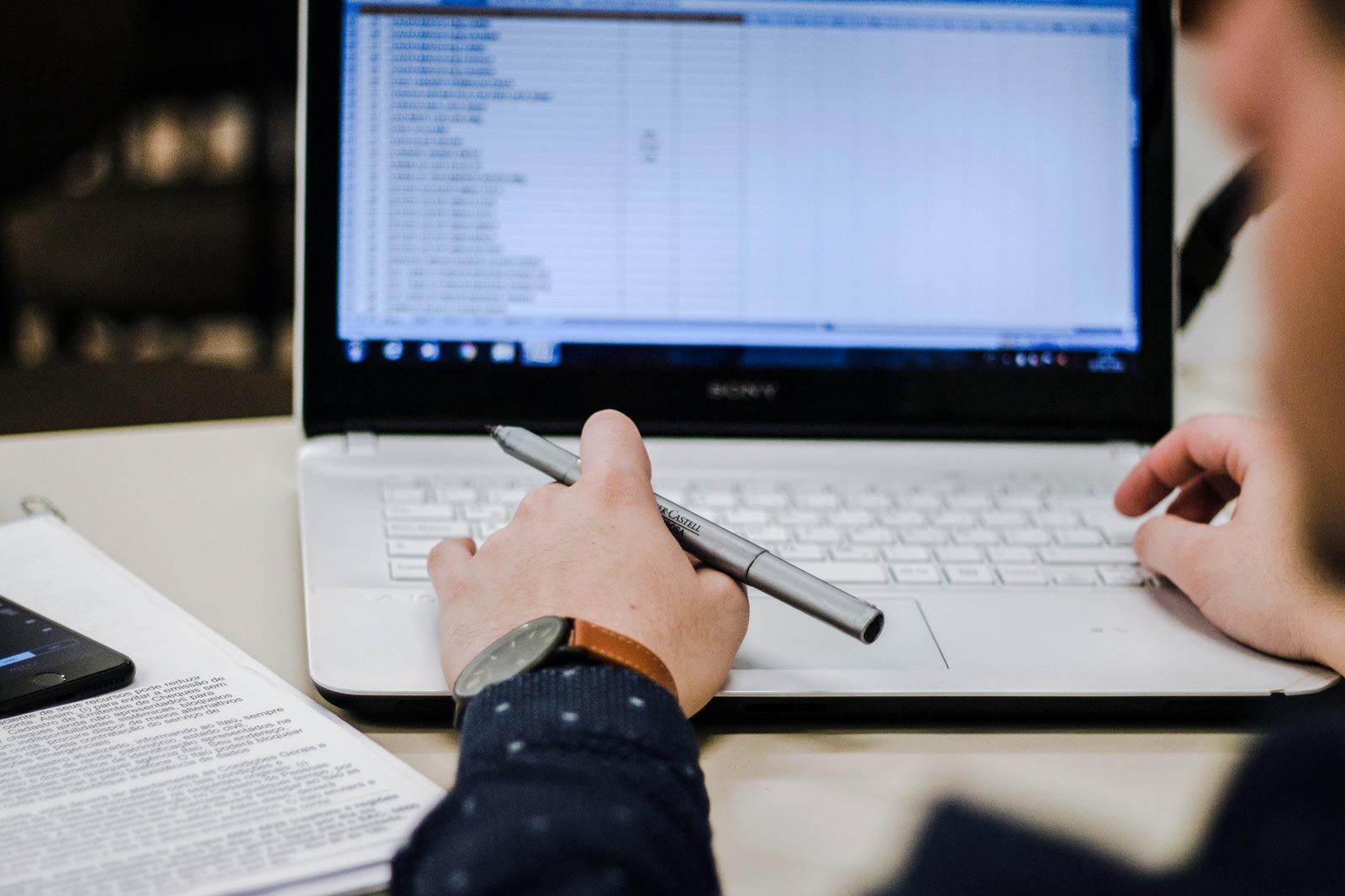 closeup of staff member working on spreadsheet on laptop computer